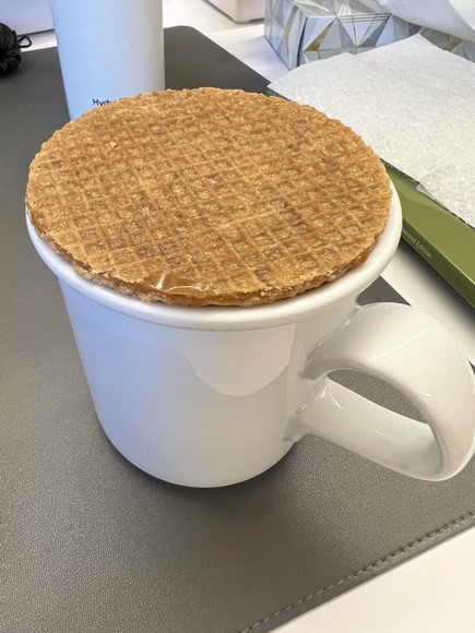 Bánh Stroopwafel úp trên miệng cốc cà phê nóng theo cách ăn truyền thống Hà Lan