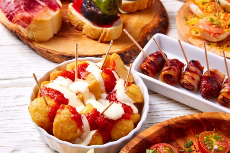 Các đĩa tapa nhỏ xếp cạnh một đĩa ración đầy đủ để so sánh khẩu phần
