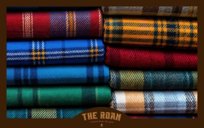 Cuộn vải tartan nhiều tông màu xếp chồng trong một xưởng dệt truyền thống Scotland