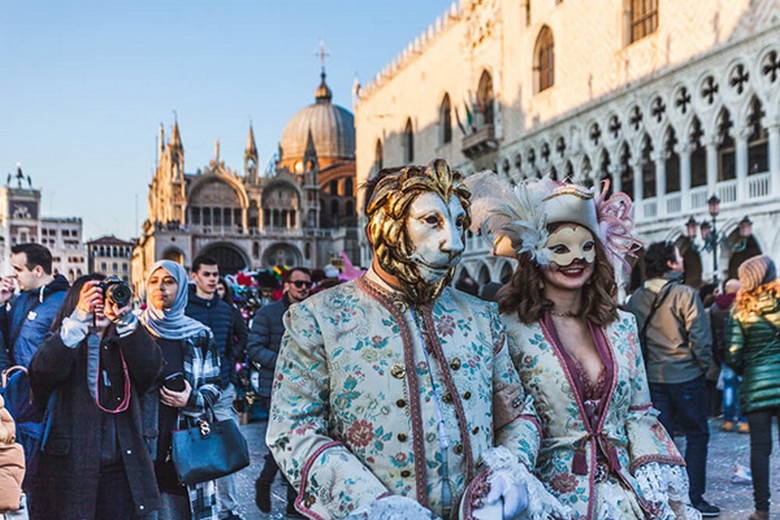 Du khách thử mặt nạ tại một quầy hàng lưu niệm trên phố cổ Venice