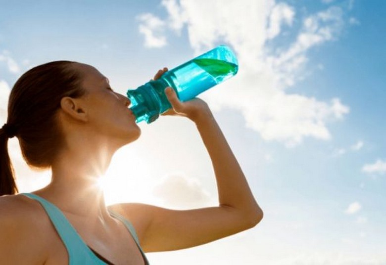 Du khách uống nước tránh mất nước khi tham quan ngoài trời