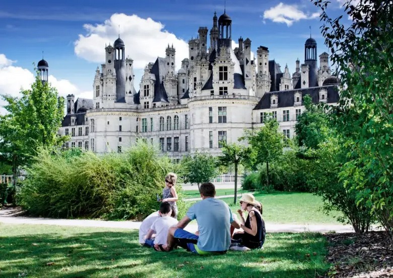 Gia đình nhiều thế hệ đi dạo trong sân lâu đài Chambord