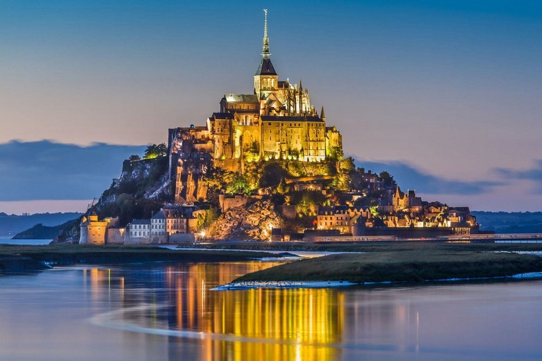Khách du lịch chụp ảnh Mont Saint-Michel từ xa lúc hoàng hôn