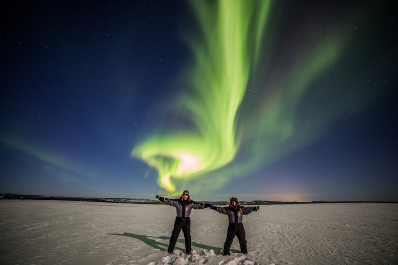 Khách du lịch ngắm cực quang trên nền tuyết trắng Lapland