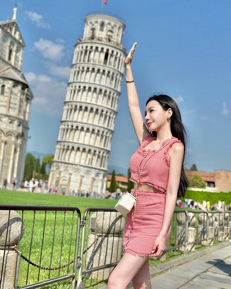 Khách du lịch tạo dáng chụp ảnh đỡ tháp nghiêng Pisa ở bãi cỏ phía bắc quảng trường