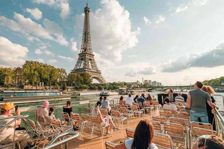Khách du lịch trên boong thuyền ngắm cảnh sông Seine