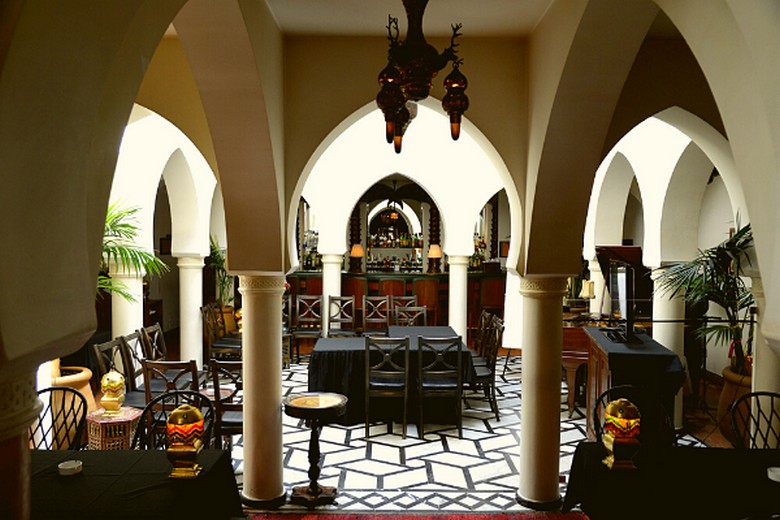 Không gian bên trong quán Rick's Café với piano và đèn vòm kiểu Maroc