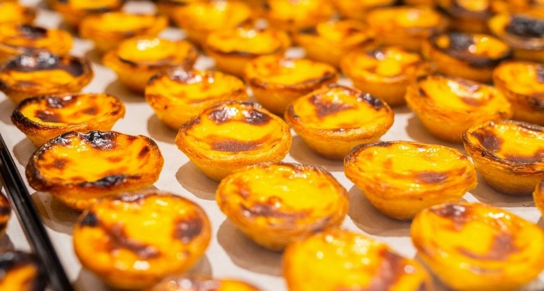 Khay bánh Pastel de Nata vừa ra lò rắc quế tại một tiệm bánh ở Lisbon