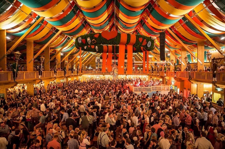 Lều bia Oktoberfest rực rỡ ánh đèn với hàng nghìn người ngồi kín các dãy bàn dài