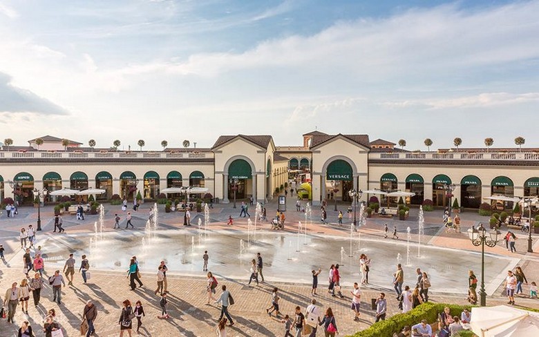 Lối đi ngoài trời với các cửa hàng hàng hiệu tại một outlet ở Ý