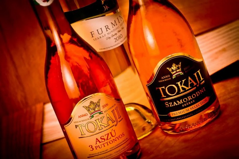 Ly rượu Tokaji Aszú màu hổ phách bên cạnh phô mai và gan ngỗng