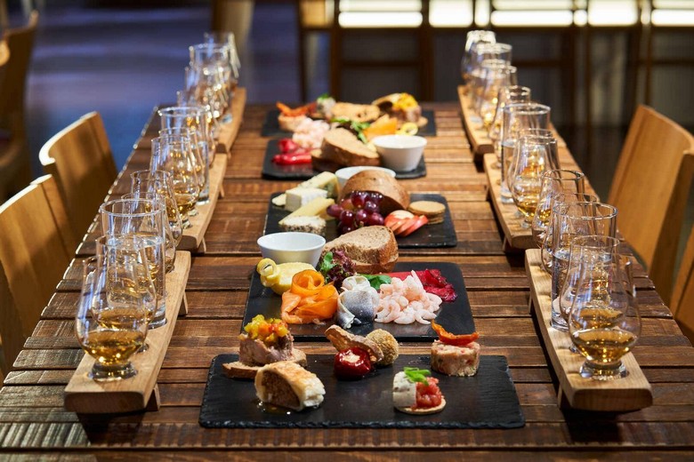 Ly whisky và lon Irn-Bru màu cam đặt cạnh món ăn Scotland