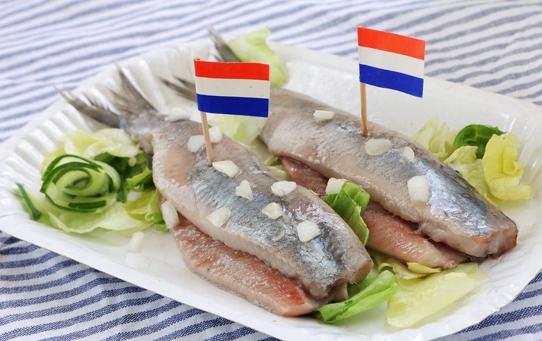 Một suất cá trích Hollandse Nieuwe cắt nhỏ ăn kèm hành tây băm tại quầy đường phố