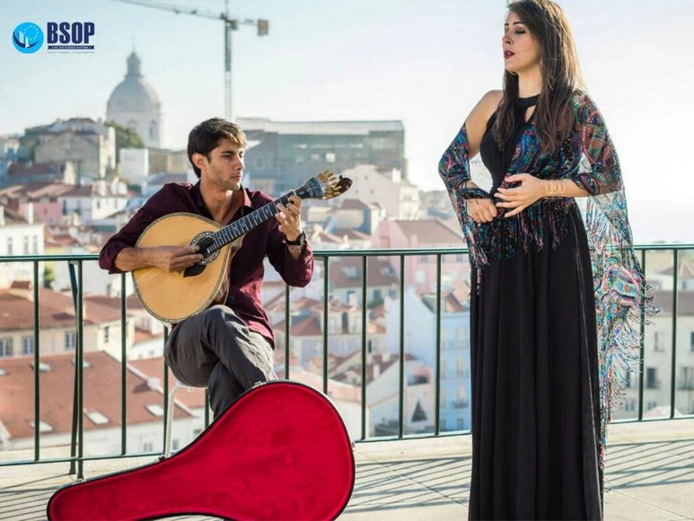 Nữ ca sĩ fadista choàng khăn đen hát dưới ánh đèn vàng trong một quán nhỏ ở Lisbon