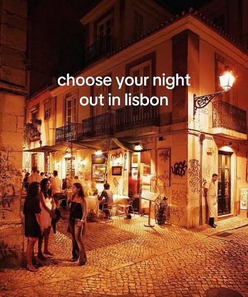Ngõ nhỏ lát đá ở Alfama buổi tối với biển hiệu casa de fado sáng đèn