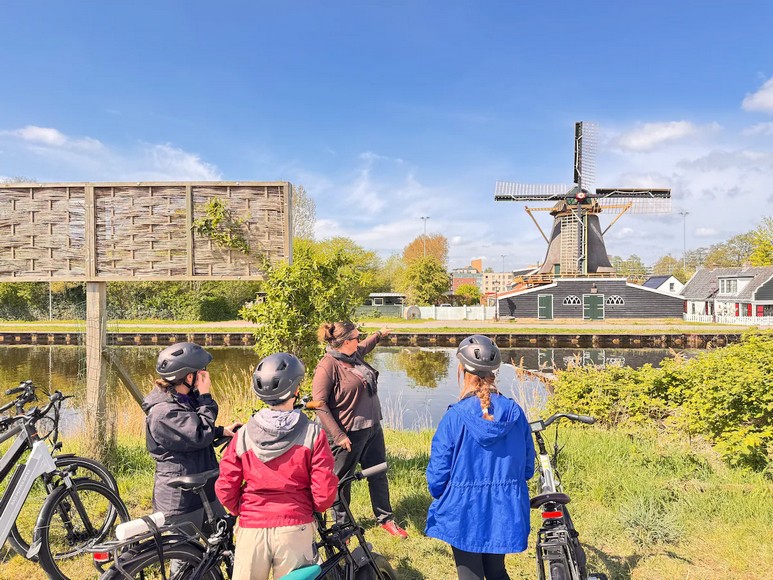 Người dân đạp xe dọc một con kênh đào ở trung tâm Amsterdam
