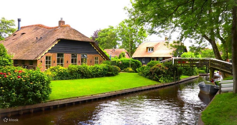 Nhà mái tranh Giethoorn nhìn từ kênh đào với cầu gỗ vòm