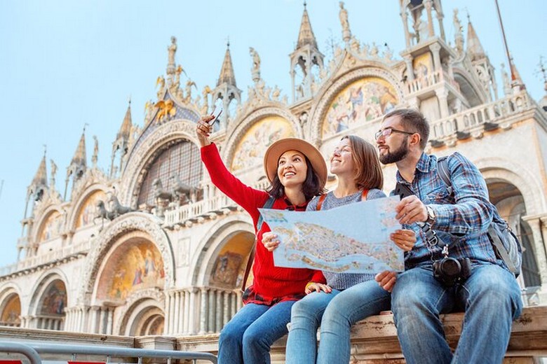Nhóm khách du lịch Việt Nam chụp ảnh lưu niệm bên kênh đào Venice trong trang phục ấm mùa đông