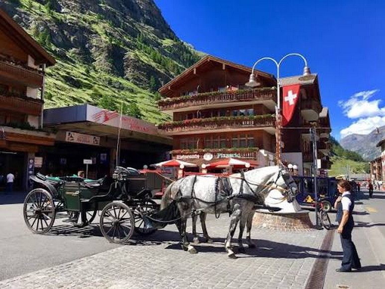 Phố đi bộ trung tâm Zermatt với xe ngựa kéo truyền thống và dãy nhà gỗ kiểu Alps