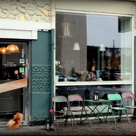 Quán cà phê ấm cúng thắp nến bên cửa sổ nhìn ra phố tuyết ở Copenhagen