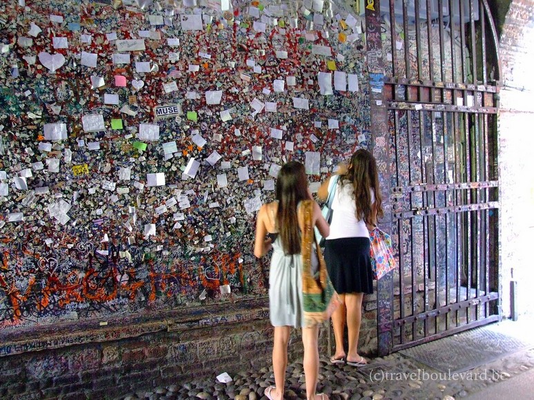 Tường đá phủ kín giấy note và thư tình của du khách tại lối vào Casa di Giulietta