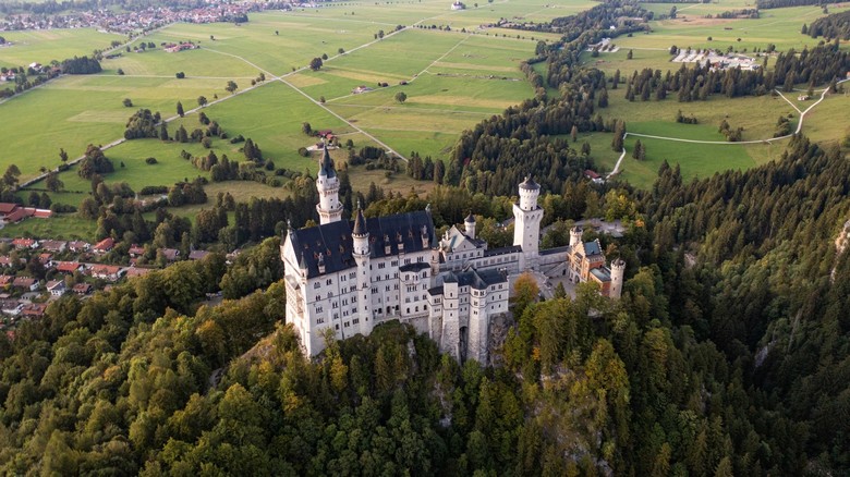 Toàn cảnh lâu đài Neuschwanstein nổi bật giữa rừng núi Bavaria nhìn từ xa