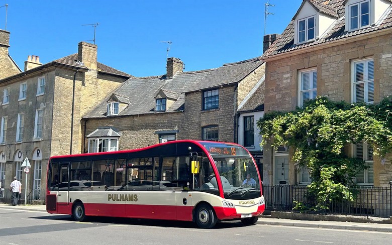 Xe buýt nhỏ chạy trên con đường quê hẹp giữa vùng Cotswolds
