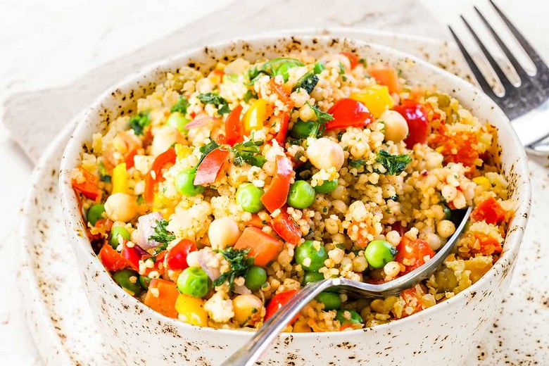 Đĩa couscous 7 loại rau củ lớn đặt giữa bàn ăn gia đình Maroc