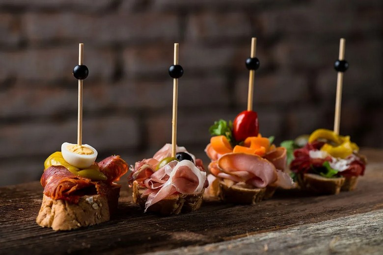 Đĩa pintxos với các cây tăm ghim trên từng miếng bánh mì tại quầy Basque